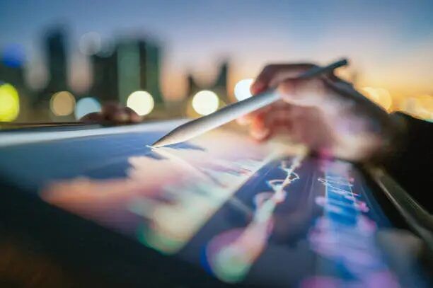 Tangan menggunakan stylus untuk menggambar grafik di tablet.