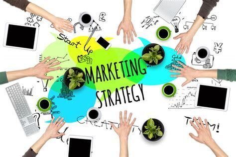 Grafik strategi pemasaran dengan tangan berinteraksi di sekitar teks 'Startup Marketing Strategy'.