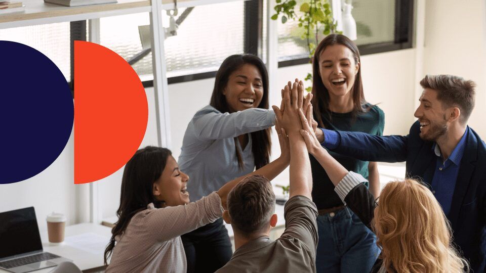 Grup orang sedang merayakan dengan high five di kantor.