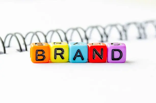 Kubus warna-warni menulis kata 'BRAND' di atas latar belakang spiral