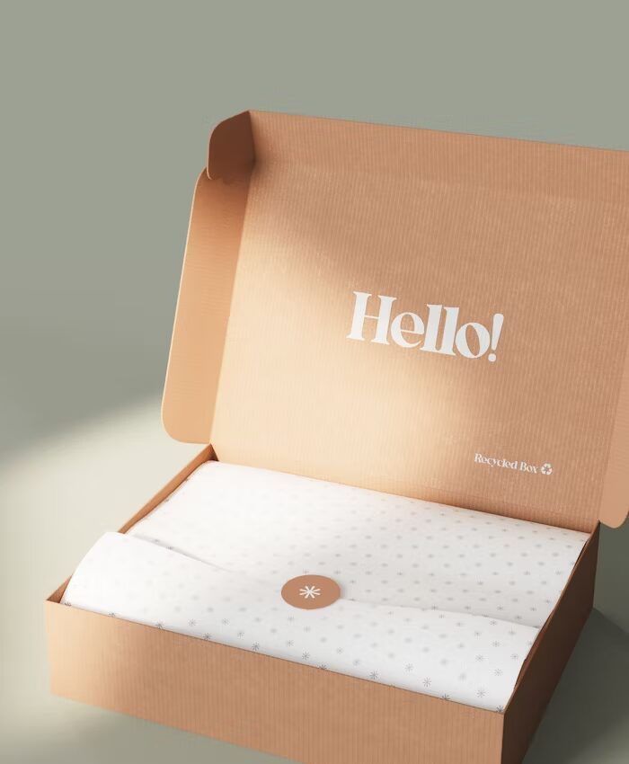 Kotak kardus terbuka dengan tulisan Hello! dan label Recycled Box di dalamnya.