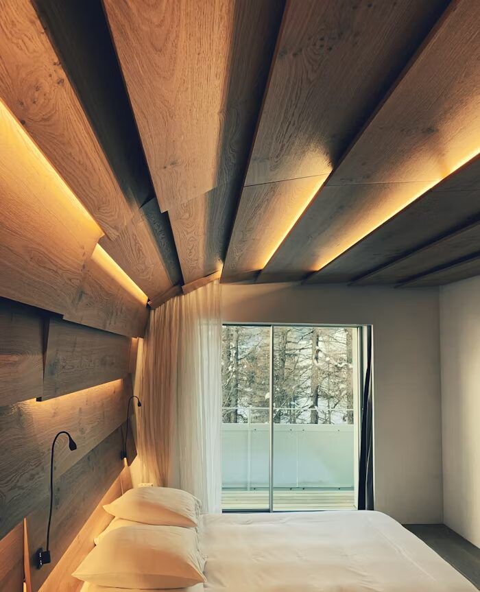 Kamar tidur minimalis dengan atap kayu dan pemandangan alam