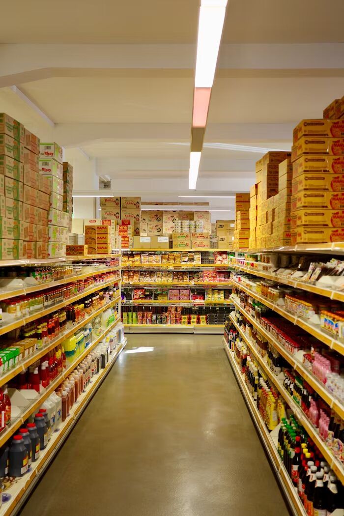 Lemari supermarket penuh dengan berbagai jenis produk makanan dan minuman.