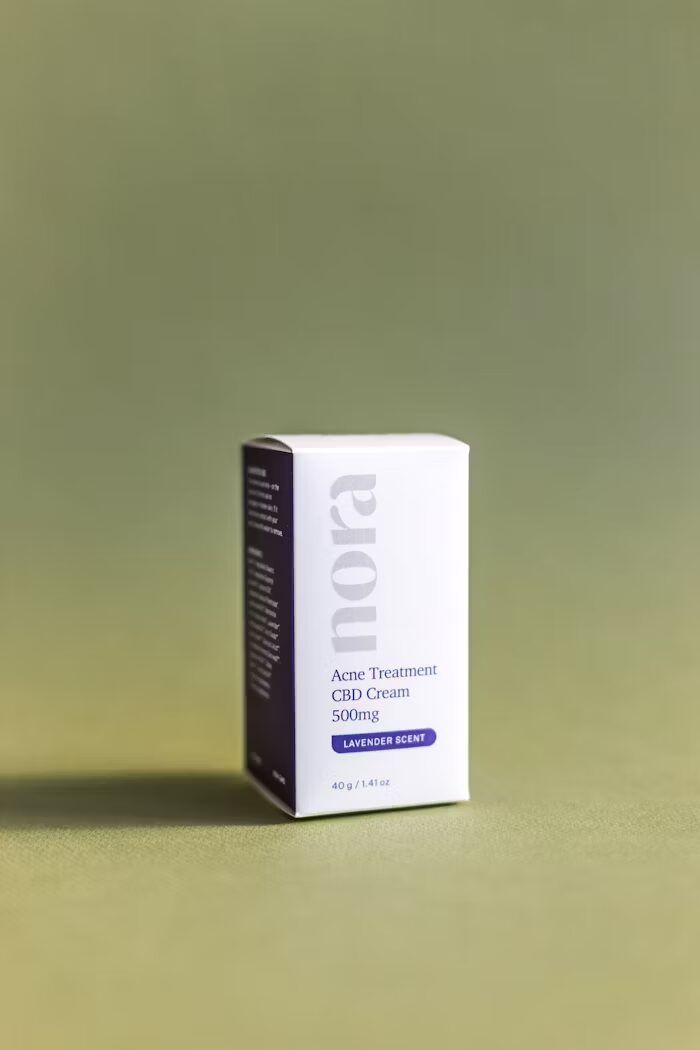 Kemasan produk perawatan kulit dengan label 'Acne Treatment CBD Cream' dan '500mg'