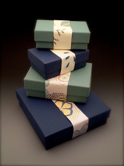 Empat kotak hadiah berwarna cerah dengan sabuk cantik, ideal untuk perayaan.