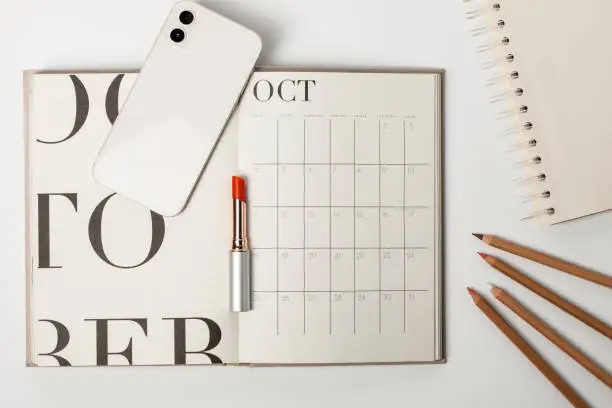 Perabot kantor modern dengan kalender, pensil, dan lipstik.