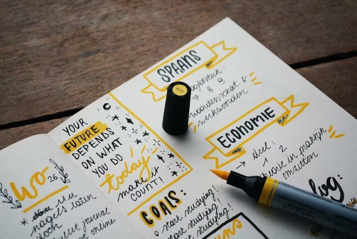 Notepad dengan tulisan motivasi dan alat tulis