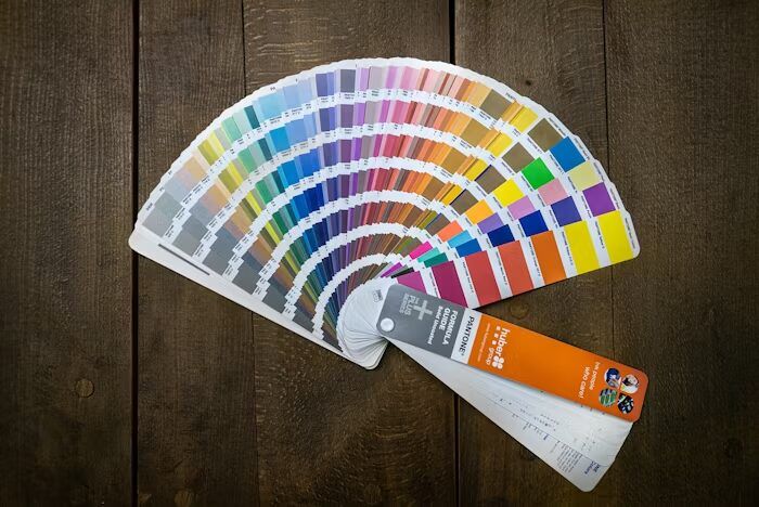 Buku warna Pantone terbuka menampilkan berbagai pilihan warna.