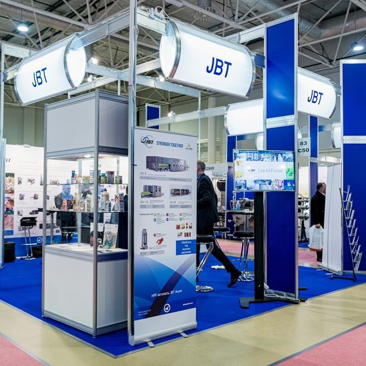 Stall Uprint.id dengan logo JBT dan peralatan cetak di latar belakang.
