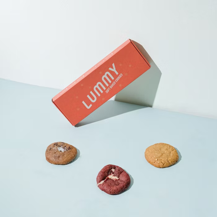 Kue kering Lummy di depan kotak kemasan merah muda, produk Uprint.id.