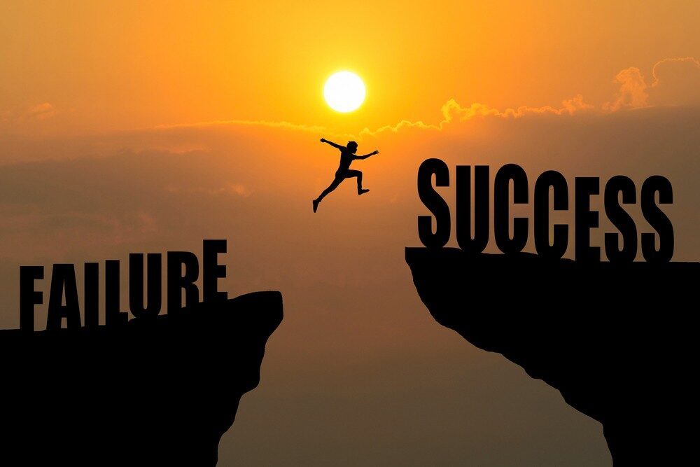 Garis lurus antara kata 'Failure' dan 'Success' dengan siluet orang lompat di tengah.
