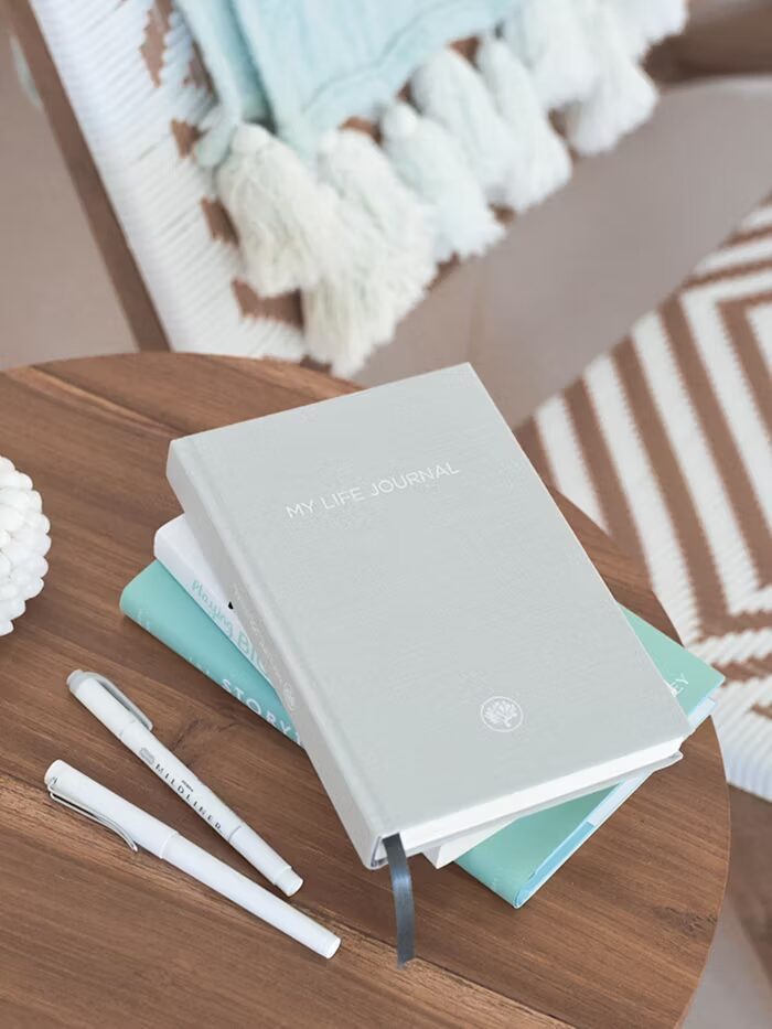Buku My Life Journal dan alat tulis di meja kayu