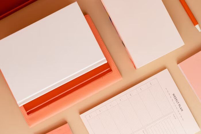 Nota dan agenda dengan warna cerah ideal untuk organisasi harian kantor.