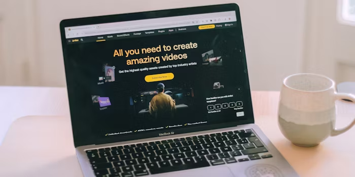 Laptop menampilkan situs Uprint sebagai ilustrasi perencanaan materi cetak branded yang terhubung dengan identitas visual brand.
