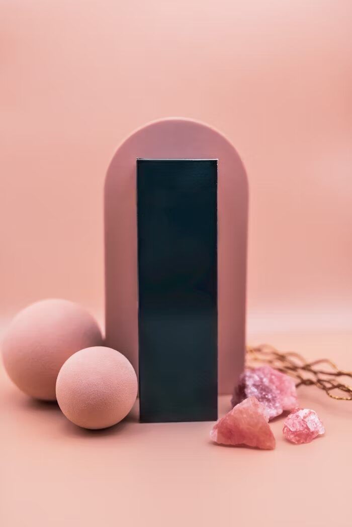 Komposisi minimalis dengan objek geometris dan batu alam berwarna pink