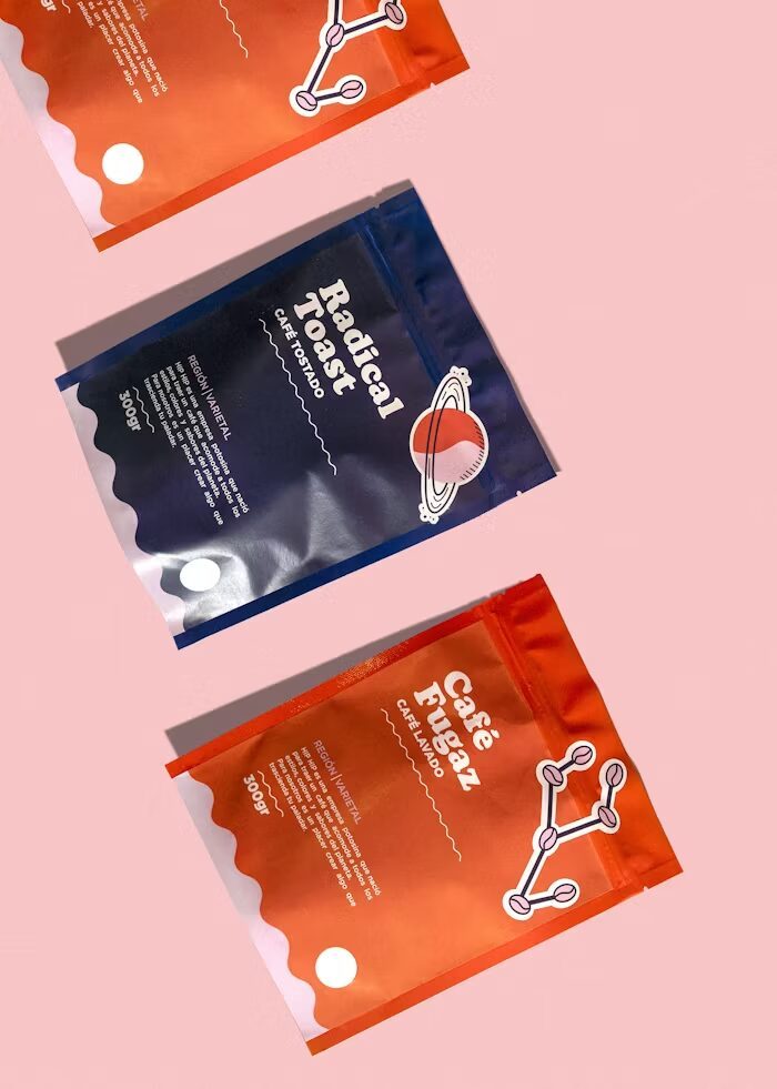 Tiga paket kopi dengan desain unik di latar pink.