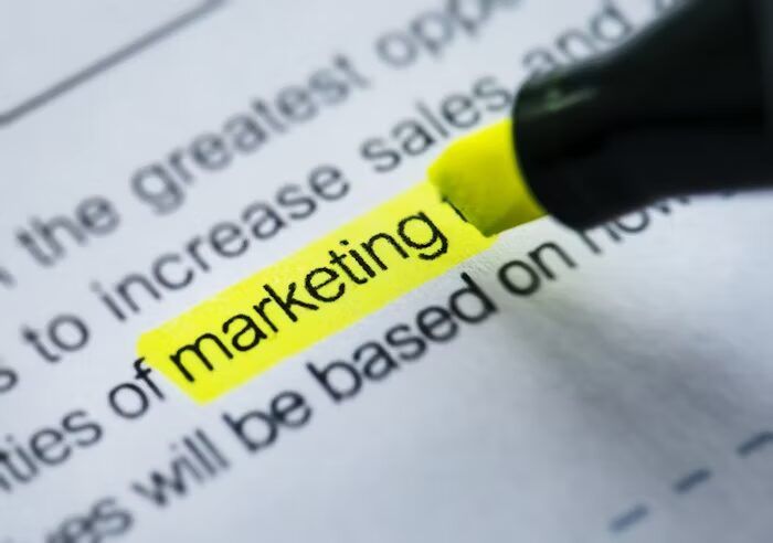 Teks 'marketing' dicoret dengan marker kuning di dokumen