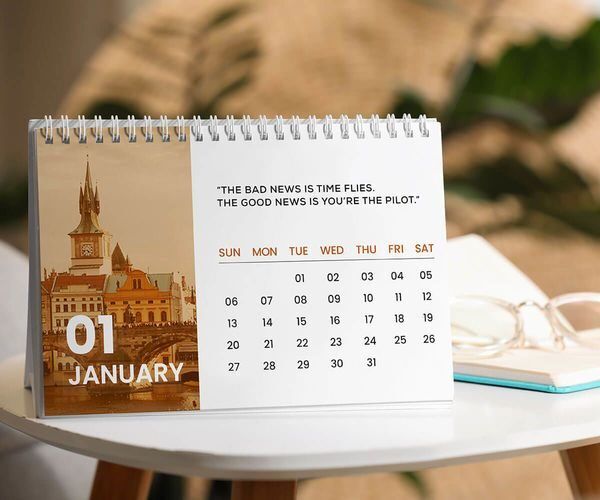 Kalender meja bulan Januari dengan citra kota tua dan kata-kata motivasi.