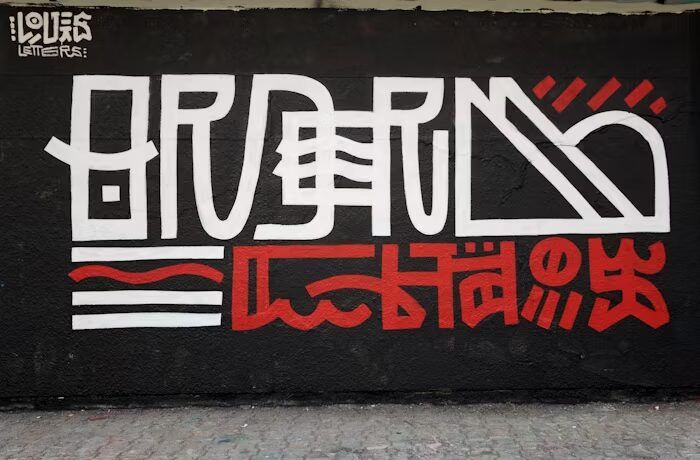 Graffiti artwork featuring bold white and red letters on a black background.