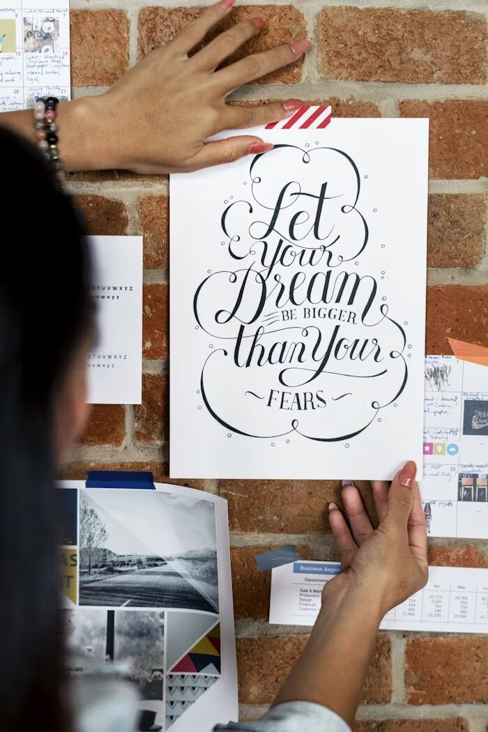 Tulisan 'Let your Dream be Bigger than your Fears' di dinding batu bata