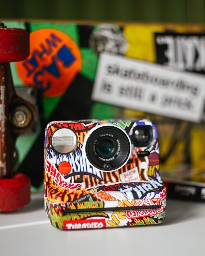 Kamera Polaroid dengan desain graffiti yang kreatif dan warna-warni.