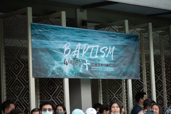 Spanduk pemotongan air baptisan dengan latar air biru.