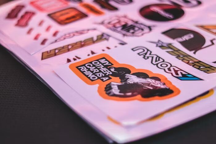 Stiker dengan desain grafis dan teks 'My Other Car is a Rhino' di atas latar belakang warna-warni.