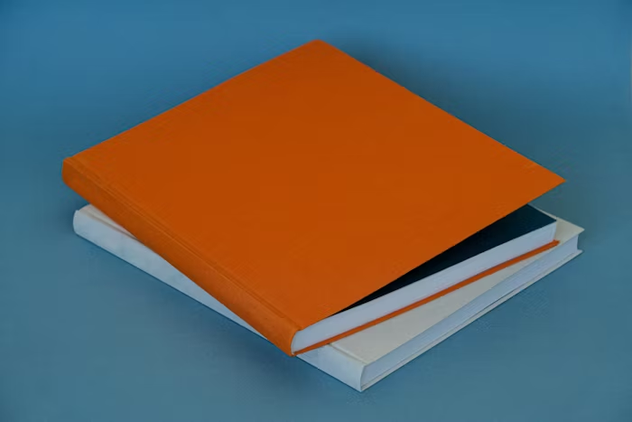 Buku hardcover dengan lembaran putih dan orange untuk gambaran cover photobook premium A5 landscape