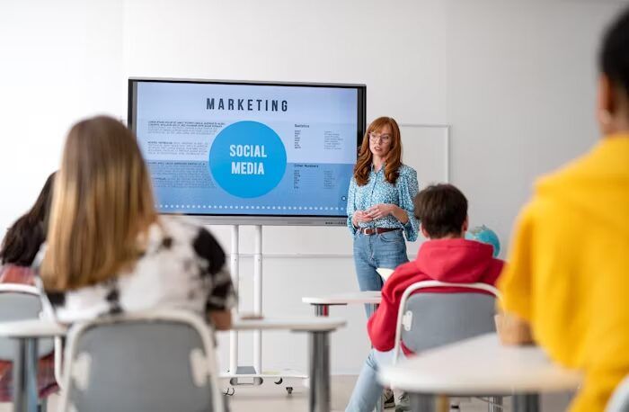 Guru mempresentasikan topik 'Marketing Social Media' kepada siswa di kelas.