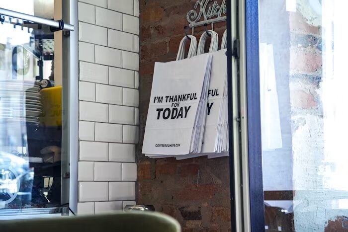Pouch putih dengan tulisan 'I'm Thankful for Today' di dinding dapur
