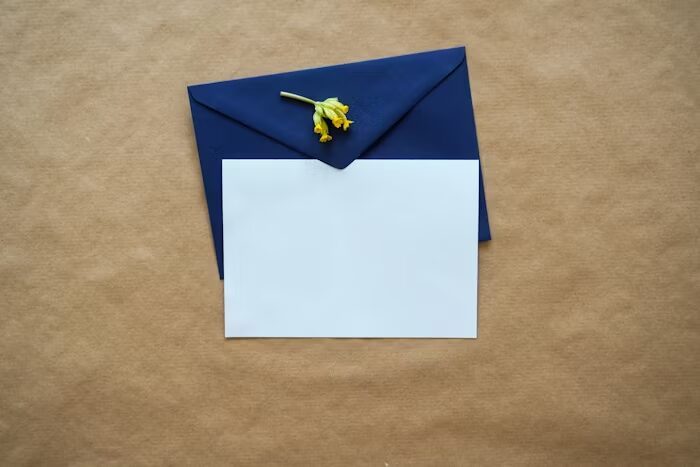 Envelop biru dengan kertas putih dan bunga kecil, konsep elegan.