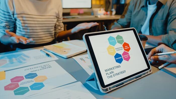 Tabel dan tablet menunjukkan strategi pemasaran dengan hexagon warna-warni.