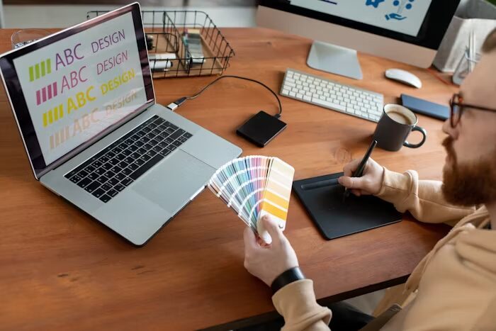 Desainer grafis memilih warna dari palet warna untuk branding produk di komputer