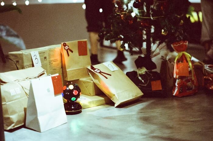 Tumpukan kemasan hadiah Natal di depan pohon Natal