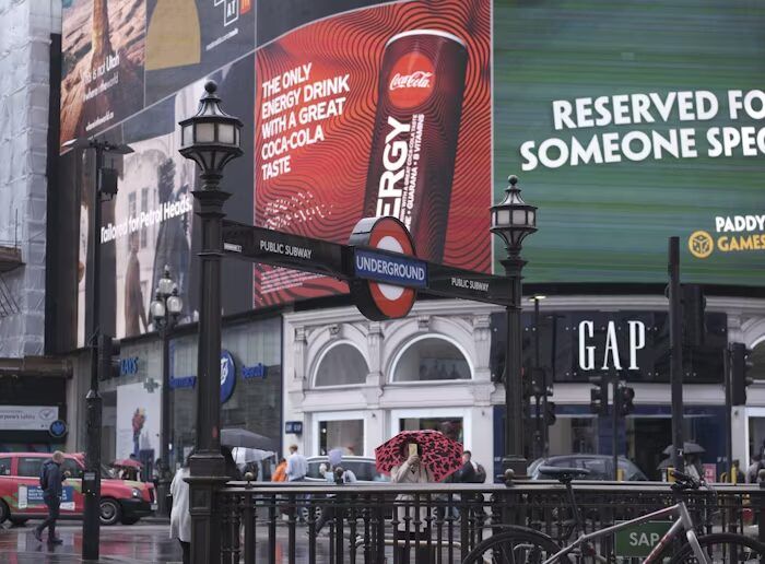 Pemandangan kota London dengan billboard besar Coca-Cola dan tanda Underground.