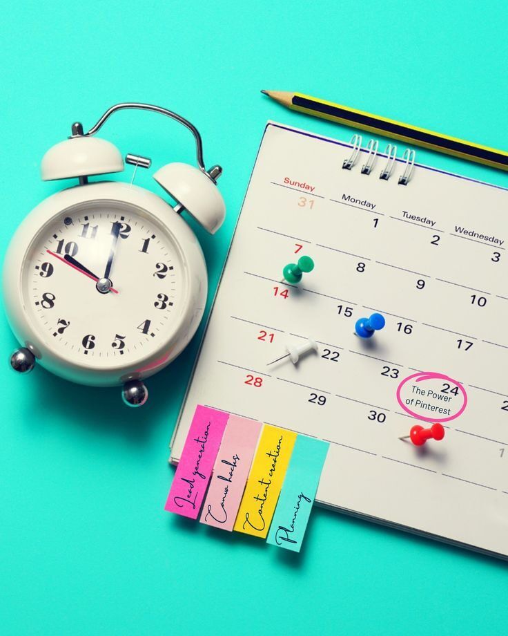 Jam alarm, catatan, dan kalender dengan pin warna-warni di atas latar biru.