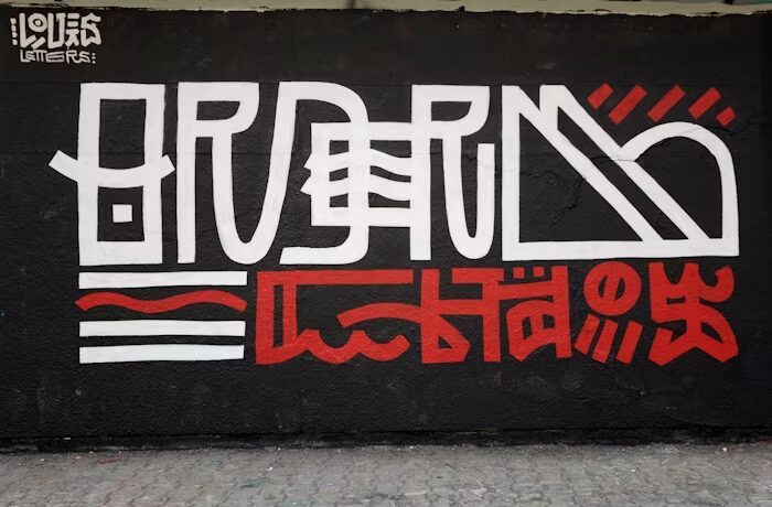 Graffiti artwork featuring bold white and red text on a black background.