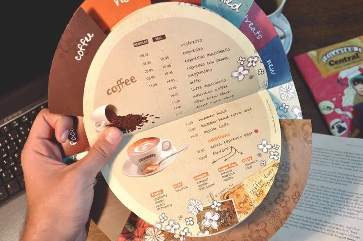 Tangan memegang menu kopi Uprint.id dengan desain menarik dan detail.