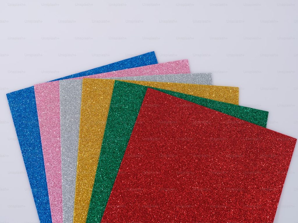Berbagai warna bahan glitter dalam lembaran, ideal untuk desain grafis dan percetakan.