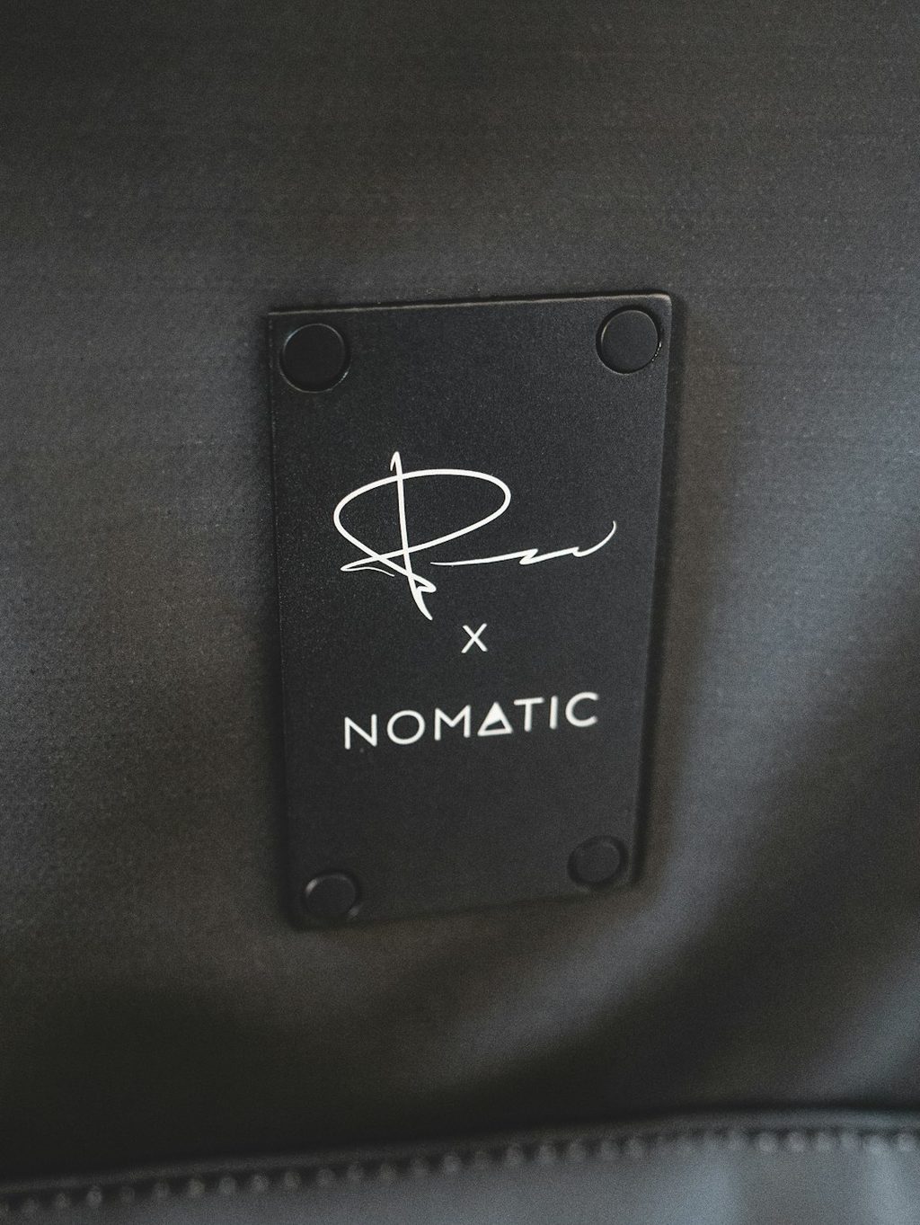 Label Nomatic terpasang pada tas hitam.