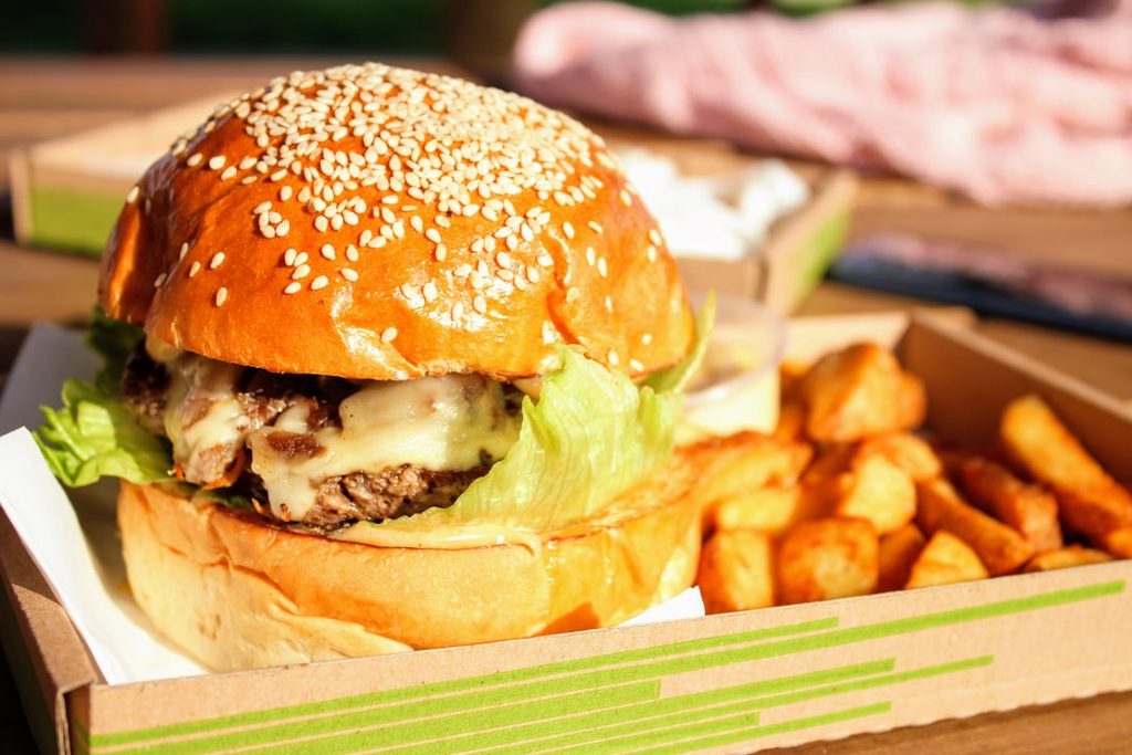 Hamburger dengan kentang goreng sebagai contoh visual makanan yang perlu didukung deskripsi menu dan cetak yang menggugah selera