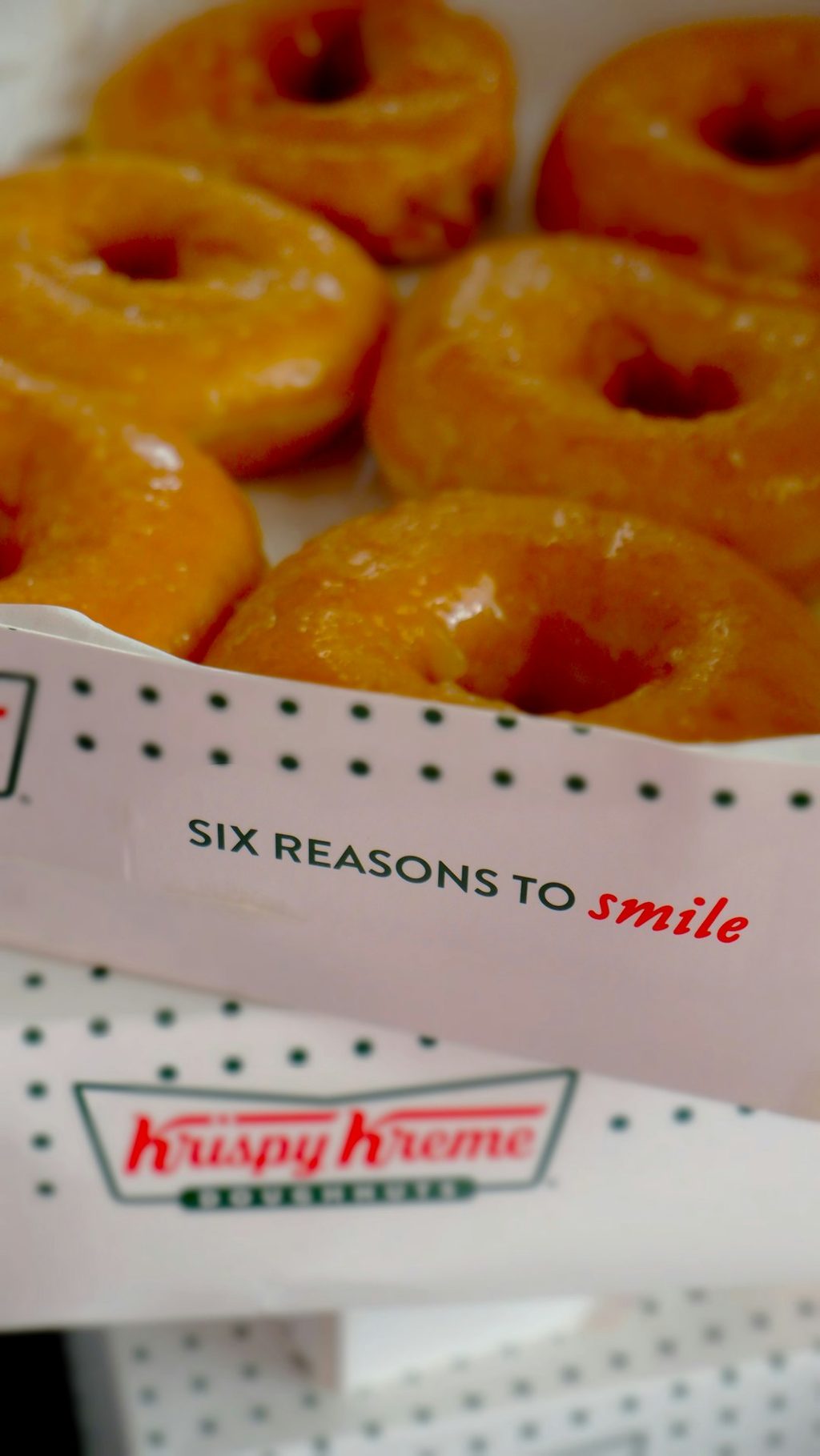 Krispy Kreme donuts in a branded box, ready to be served.