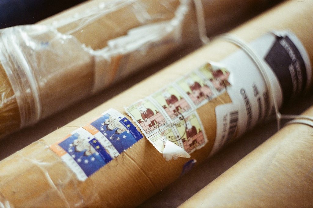 Close-up of rolls of paper wrapped in plastic with stickers, suitable for printing and packaging materials.