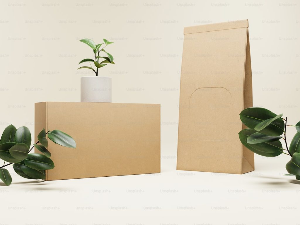 Paket percetakan online Uprint.id dengan kemasan kraft dan tanaman hias.