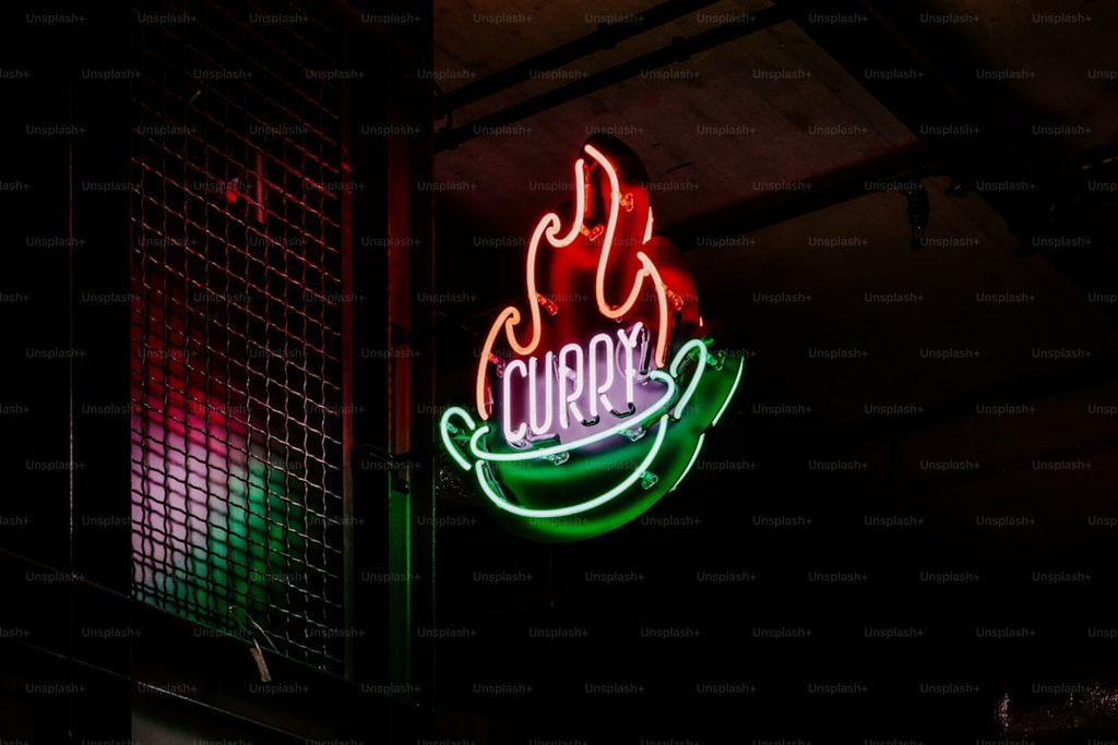 Neon sign yang menunjukkan logo 'Curry' dengan desain makanan