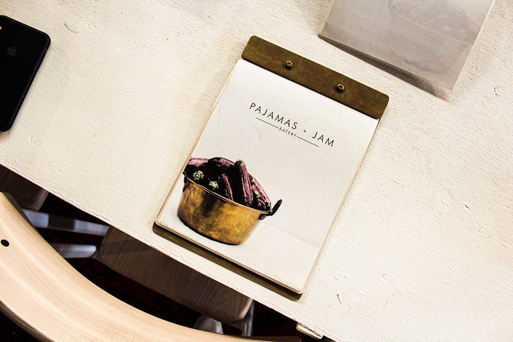 Notebook with 'Pajamas - Jam' text and illustration of a bag on a white surface.