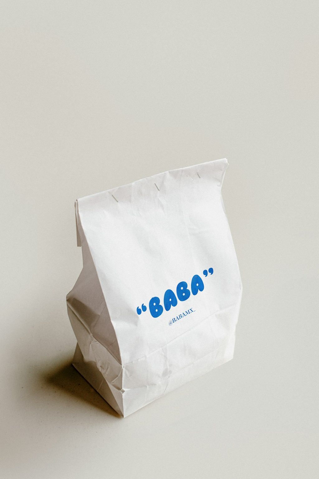 Kemasan putih bertuliskan BABA yang menunjukkan desain minimalis untuk branding makanan premium