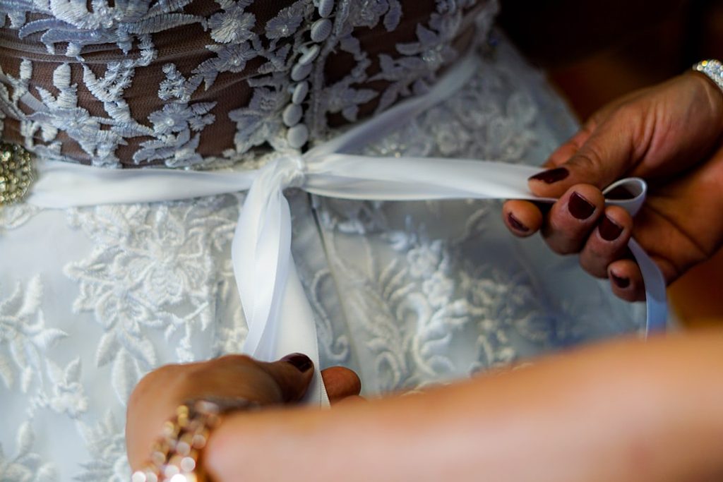 Tangan mempersiapkan rok pengantin dengan hiasan putih untuk koleksi butik premium.