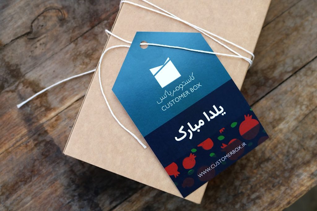 Hangtag dengan logo Customer Box dan pesan selamat datang dalam bahasa Arab dan Inggris.