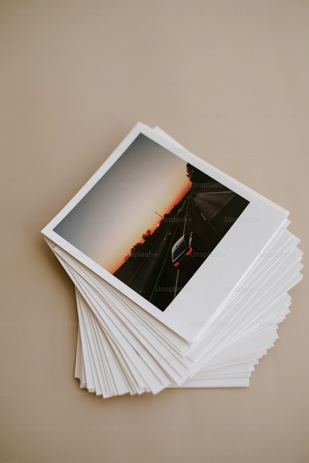 Stack of Polaroid-style prints on a neutral background.